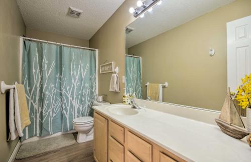 a bathroom with a tub and a toilet and a sink at Waterfront Townhome with Private Dock and Lake Views in Lake Ozark