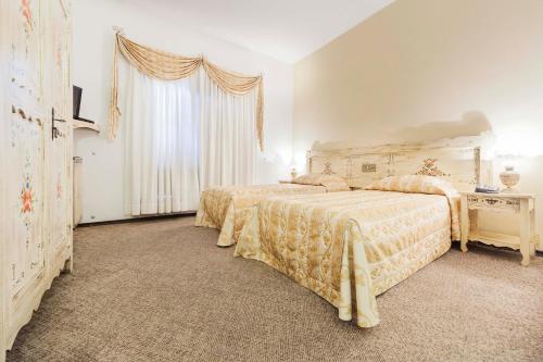 a bedroom with two beds and a window at Hotel Tannenhof in Joinville