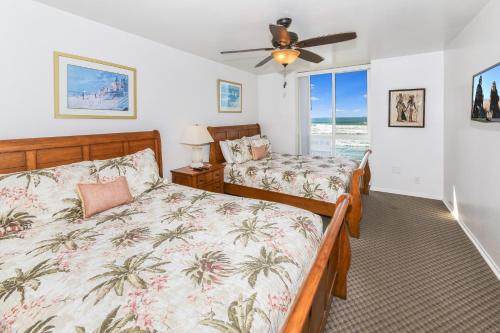 een slaapkamer met 2 bedden en een plafondventilator bij E20 - Tropical Paradise - On-the-Sand in Oceanside