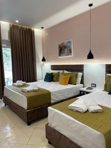 two beds in a hotel room with two bedsitures at Relax Apts Saranda in Sarandë