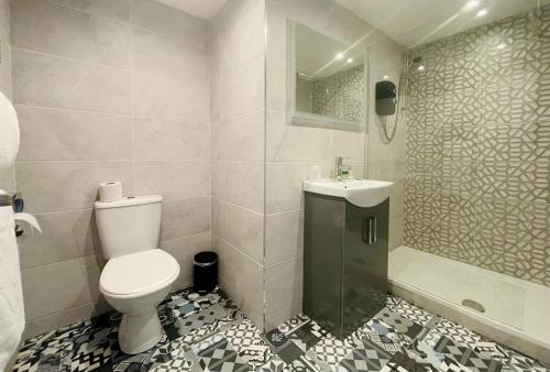 a bathroom with a toilet and a sink and a shower at Burlington Guest House in Whiting Bay