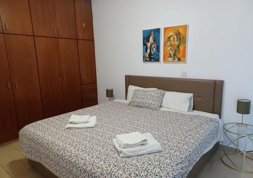 a bedroom with a bed with two towels on it at King's Holiday Apartments in Paphos City
