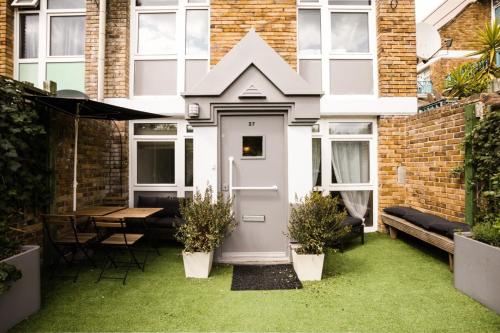 a house with a white door in a garden at Homely 4 Bedroom House in Brixton in London