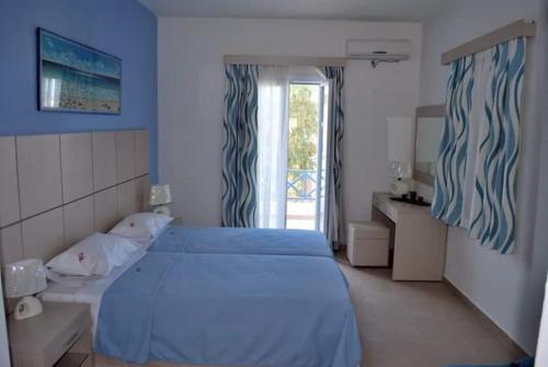 a bedroom with a blue bed and a window at Thealos in Azolimnos Syros