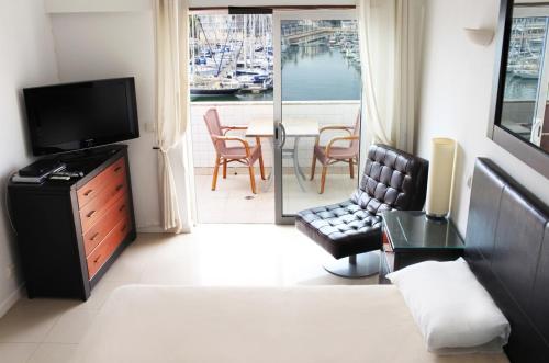 a living room with a couch and a television and a balcony at Lagos Marina View studio apartment on main avenue in Lagos