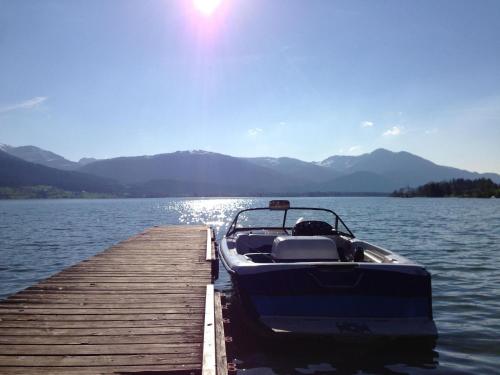 a boat parked at a dock on a lake at Seehotel Berau in St. Wolfgang