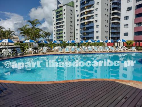 a large swimming pool in the middle of some buildings at Apto Cond Ilhas do Caribe - Pr - Beira Mar in Matinhos