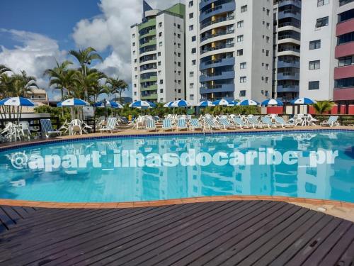 una grande piscina al centro di alcuni edifici di Apto Cond Ilhas do Caribe - Pr - Beira Mar a Matinhos