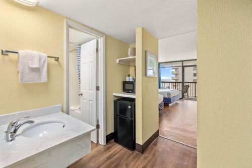 a bathroom with a sink and a view of a room at North Shore Oceanfront Resort Hotel in Myrtle Beach