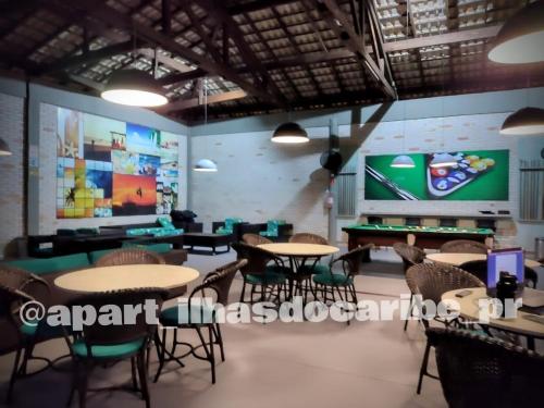 a restaurant with tables and chairs and a pool table at Apto Cond Ilhas do Caribe - Pr - Beira Mar in Matinhos