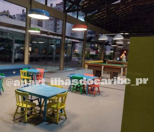 a room with tables and chairs and a pool table at Apto Cond Ilhas do Caribe - Pr - Beira Mar in Matinhos