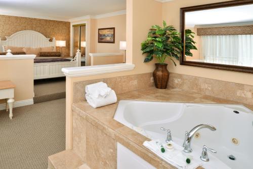 a bathroom with a tub and a large mirror at Dana Point Marina Inn in Dana Point