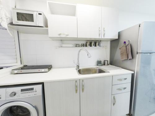 a small kitchen with a sink and a microwave at Great Location Fully Equipped in Eilat