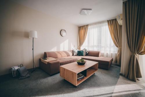 uma sala de estar com um sofá e uma mesa de centro em Unbeatable Location: New & Comfy Apartment em Varna City