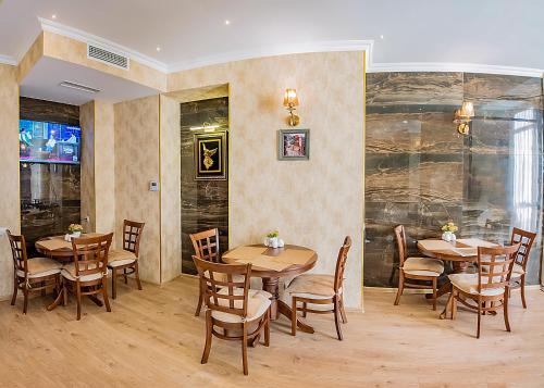 a dining room with wooden tables and chairs at Vintage Hotel in Tbilisi City