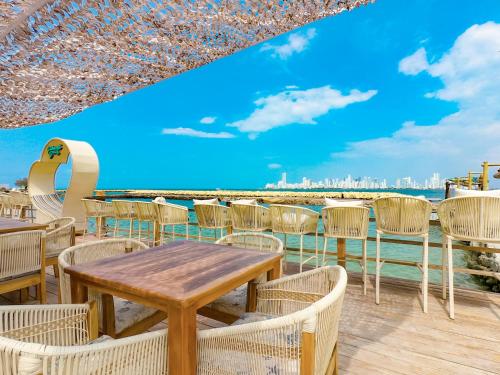 a table and chairs with a view of the beach at Palmarito Beach Hotel in Tierra Bomba
