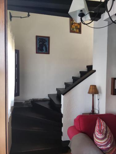 a living room with a staircase with a red couch at Falagueira in Monforte de Lemos