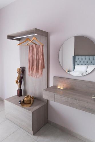 a dressing room with a mirror and a bed at Sueño Luxury Apartments in Polychrono
