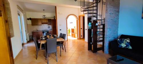 una cucina e una sala da pranzo con tavolo e sedie di Casa Pasitea a Taormina