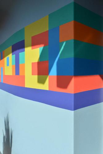 a painting of a colorful shelf with a cactus at Hotel San Fermin Pereira in Pereira