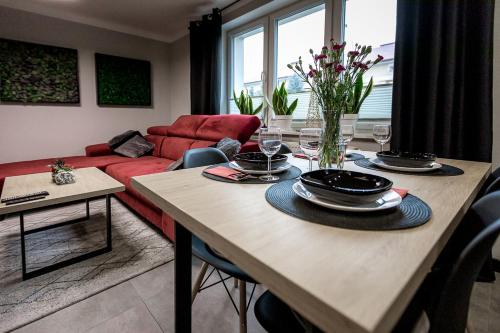 a living room with a table and a red couch at Apartament Chopin in Sanok