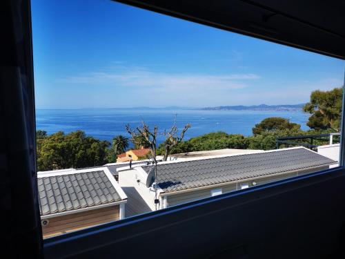 a view of the ocean from a window at Charmant Mobil home avec Vue mer exceptionnelle in Saint-Raphaël