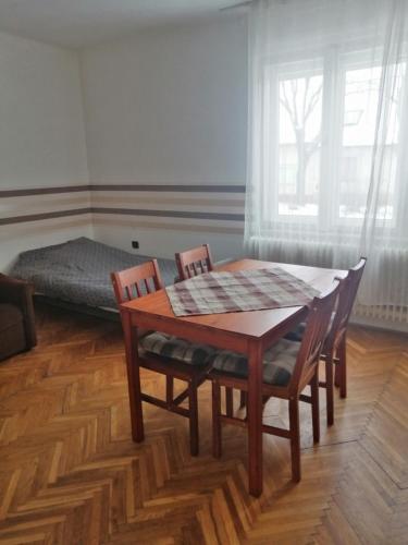 a room with a table and chairs and a bed at Belvárosi Vendégház in Miskolc