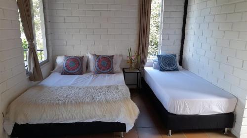 two beds in a room with two windows at Ecolodge Bahia del Peñón in Guatapé