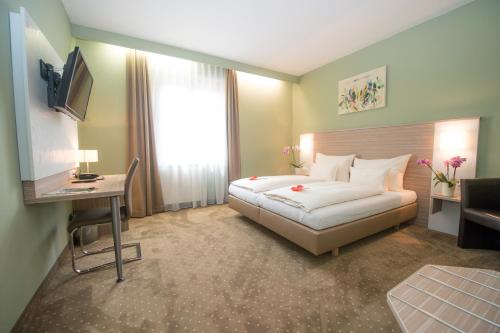 a hotel room with a bed and a desk at Hotel Raffel in Jennersdorf