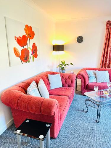 a living room with a red couch and a table at River house in Birnam