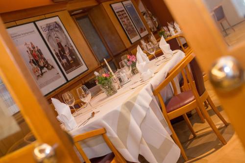 a dining room with a long table with flowers on it at Hotel Raffel in Jennersdorf