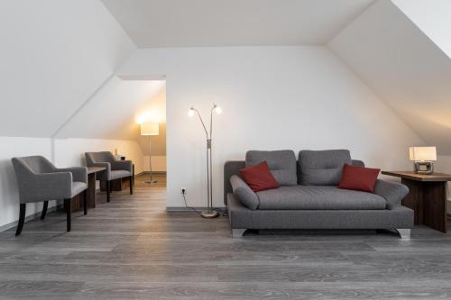 a living room with a couch and two chairs at Hotel Grosse Klus in Bückeburg