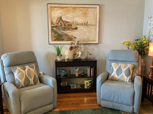 a living room with two chairs and a painting on the wall at Romantic condo for 2-Sunset Harbor Palms 1-205, pool, fishing pier in Navarre