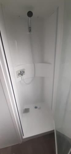 Cette chambre dispose d'un plafond blanc et d'une douche. dans l'établissement Camping 4* 3 CH 2 SDB- Lave linge- Lave vaisselle, à Onzain