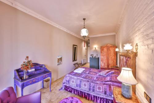 a bedroom with a purple bed and a table at Çetmihan Hotel in Kucukkuyu