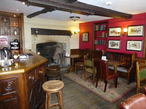 a bar with tables and chairs and a fireplace at The Bear Hotel in Devizes