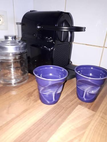 trois tasses bleues en plastique à côté d'une cafetière dans l'établissement Plage d'Erretegia et Bidart à pied, à Bidart