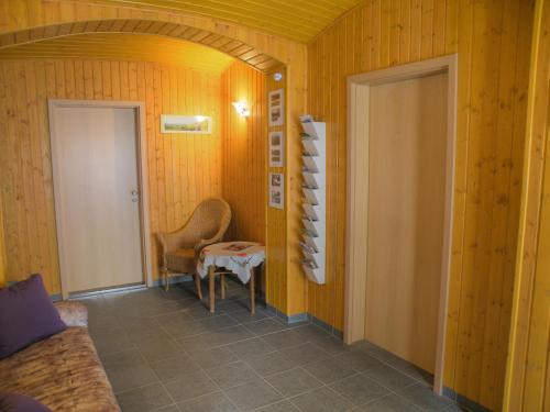 Zimmer mit einer Tür, einem Stuhl und einem Tisch in der Unterkunft Am Lindenbaum in Kirnitzschtal