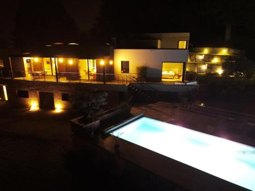 a swimming pool in front of a house at night at Grande villa de luxe in Périgueux
