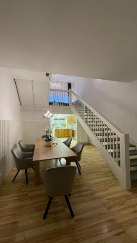 a dining room with a table and a staircase at Ferienwohnung an der Therme, Bademantelgang zur Limestherme in Bad Gögging