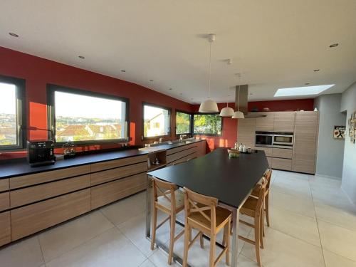 a large kitchen with a black table and chairs at Grande villa de luxe in Périgueux