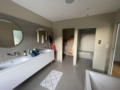a bathroom with a sink and a tub and a mirror at Grande villa de luxe in Périgueux