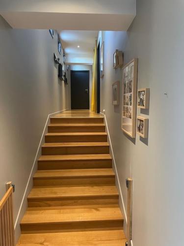 a hallway with a staircase with wooden floors and a door at Grande villa de luxe in Périgueux