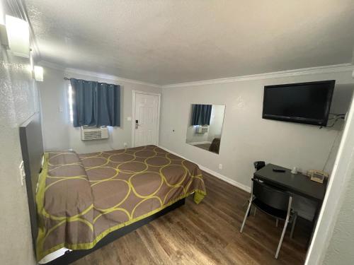 una camera con letto, scrivania e TV di Seaway Motel a Los Angeles