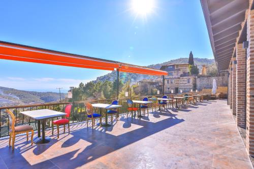 a row of tables and chairs on a balcony at Çetmihan Hotel in Kucukkuyu