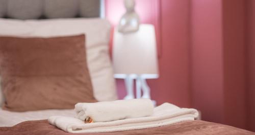 a pile of towels on a bed with a lamp at Nikolai Homes in Vienna
