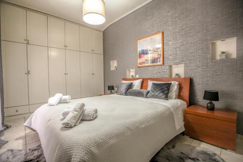1 dormitorio con 1 cama grande y toallas. en Grand Meteora Central Luxury Apartment en Kalabaka