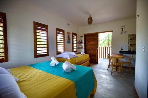 a bedroom with two beds and a table and chairs at Maluhia Lofts in Icaraí