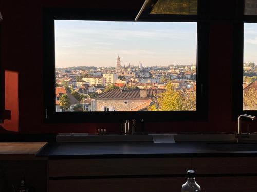 a bathroom window with a view of a city at Grande villa de luxe in Périgueux