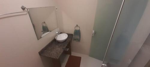 a bathroom with a sink and a mirror at Aquarela Bombinhas in Bombinhas